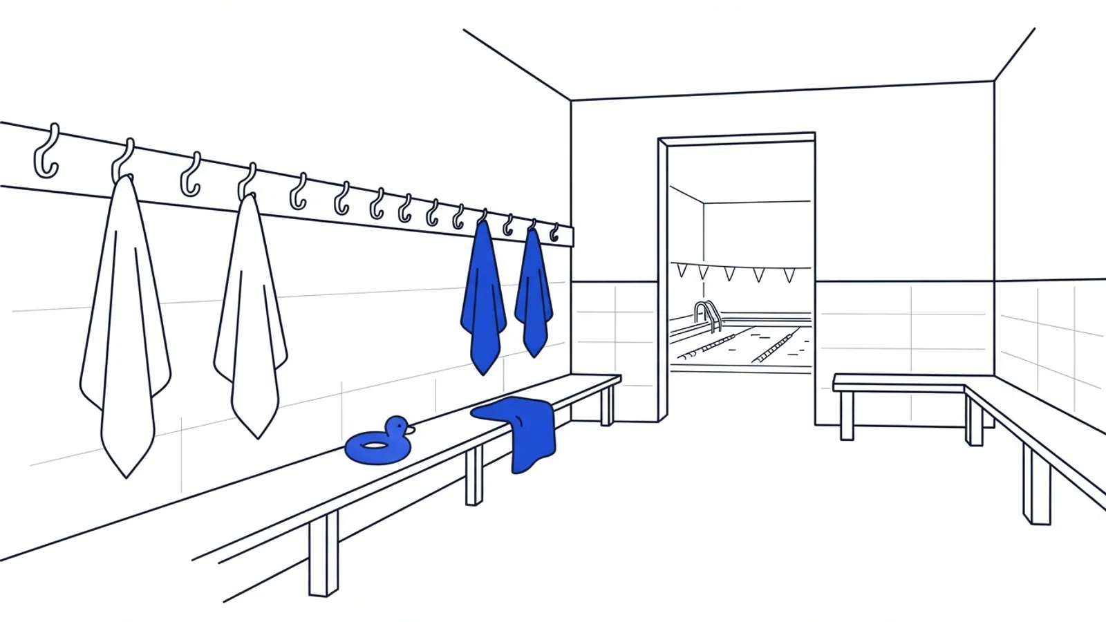 An empty community pool changing room with towels on hooks and a floating toy on a bench.