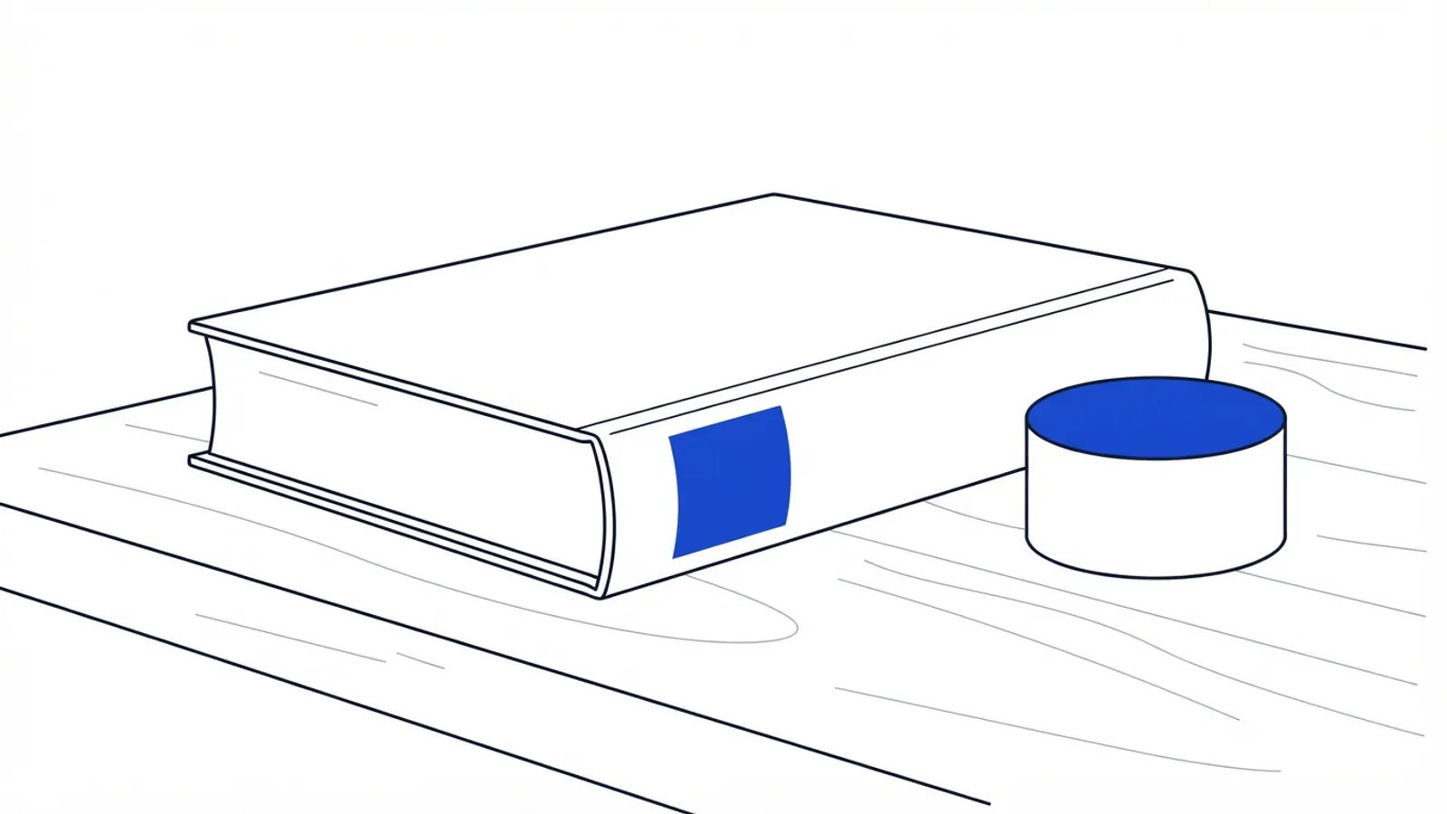 A plain, closed book and a blue and white cylindrical object on a light wooden table.